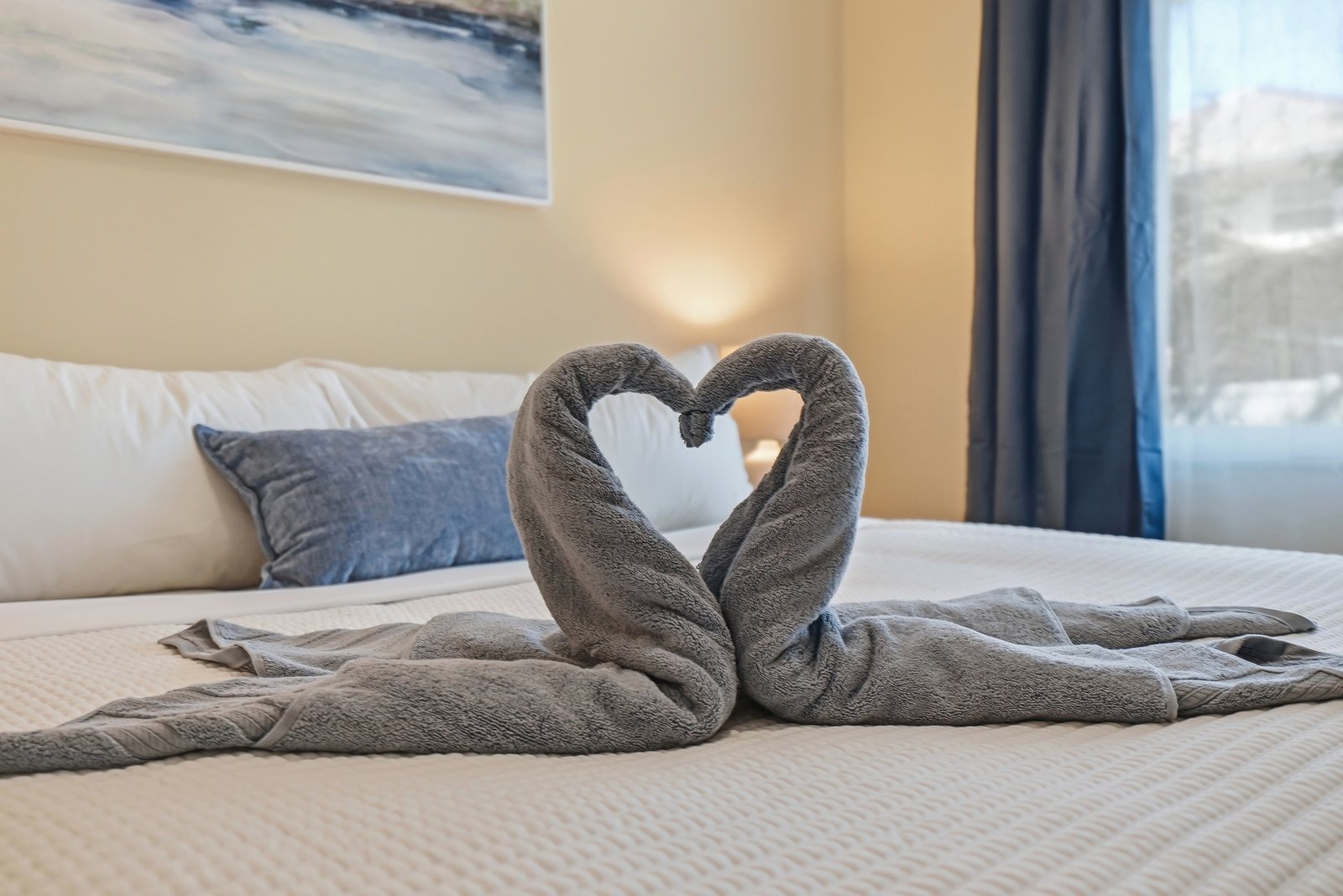 Towel swans arranged on a guest bed